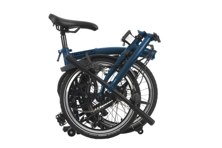 Złożony rower Brompton C-line Urban S2L Ocean Blue z czarnymi oponami i komponentami, prezentujący jego kompaktową i przenośną konstrukcję.
