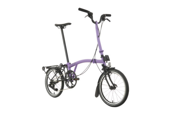 Fioletowy rower składany z tylnym bagażnikiem, pokazany na białym tle.