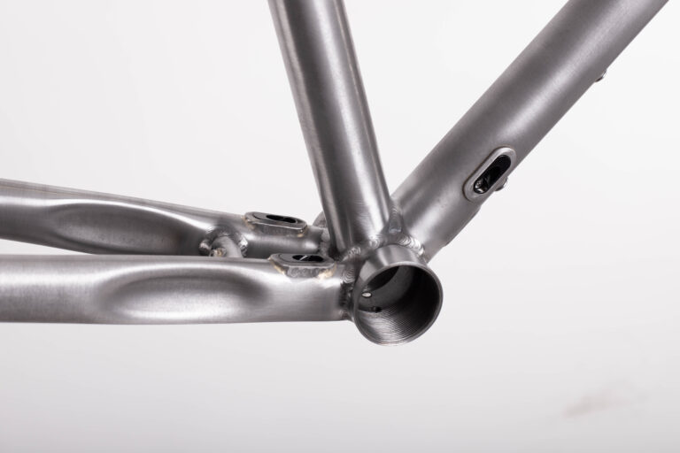 Zbliżenie ramy roweru ze szczególnym uwzględnieniem spawów i połączeń rur.
