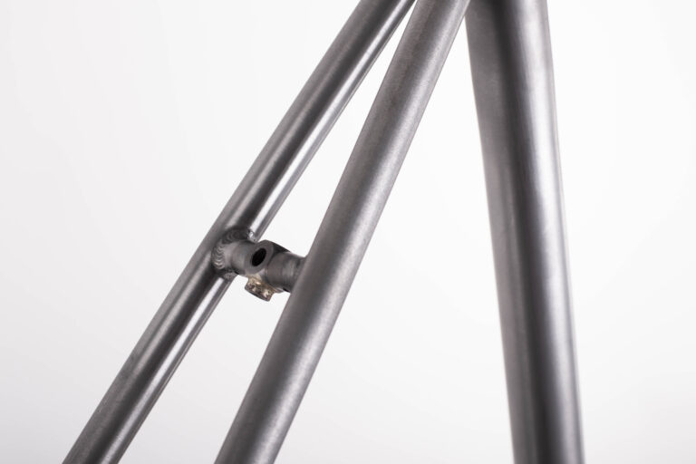 Zbliżenie ramy roweru ze szczególnym uwzględnieniem rury podsiodłowej, rury górnej i złącza wspornika siodełka.