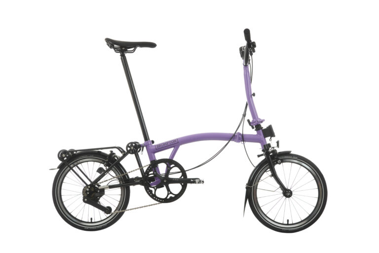 Fioletowy rower składany odizolowany na białym tle, z małymi kołami i kompaktową ramą.