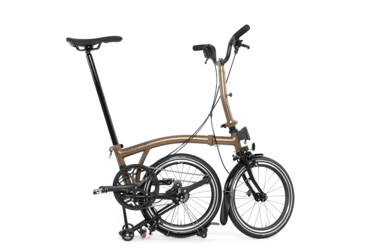 Składany Brompton P-line Urban M4R Bronze Sky z brązową ramą i czarnym siedziskiem, złożony w celu zapewnienia kompaktowego przechowywania.