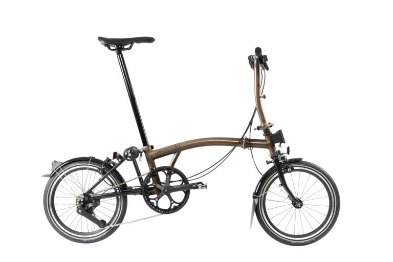 Brompton P-line Urban M4R Bronze Sky o eleganckim wyglądzie, z małymi kołami, solidną ramą i podwyższoną kierownicą zapewniającą wyprostowaną pozycję do jazdy.