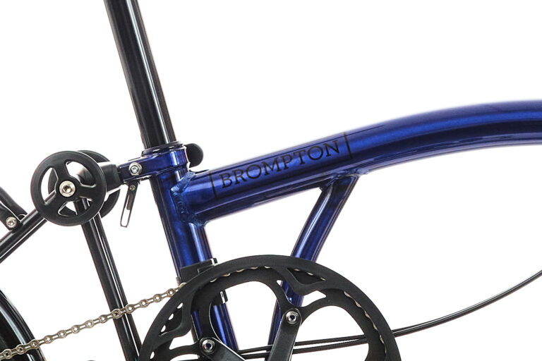 Zbliżenie ramy roweru Brompton i tarczy, z niebieskim wykończeniem.