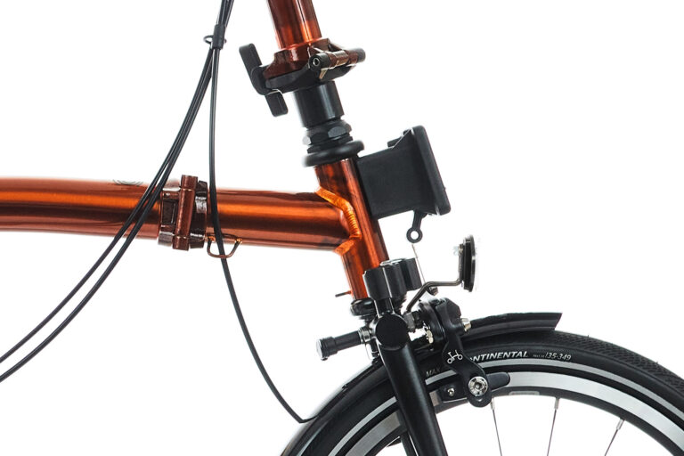 Zbliżenie roweru Brompton P-line H4L Flame Lacquer z pomarańczową kierownicą.