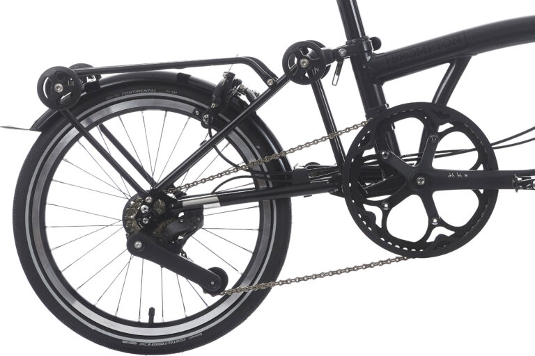 Zbliżenie tylnej części czarnego składanego roweru Brompton P-line Explore H12R Midnight Black Metallic, ze szczególnym uwzględnieniem koła, łańcucha i mechanizmu przekładni.