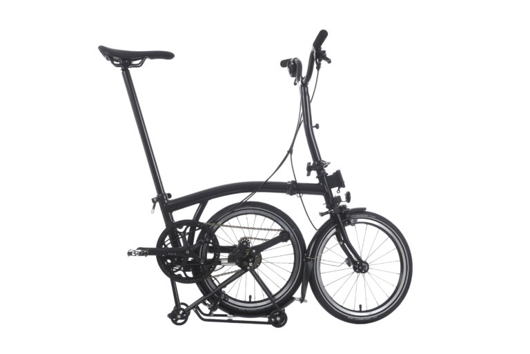 Rower Brompton P-line Explore H12R Midnight Black Metallic w kompaktowej, złożonej pozycji, charakteryzujący się smukłym profilem i innowacyjnym designem, z wysuniętą kierownicą i sztycą.