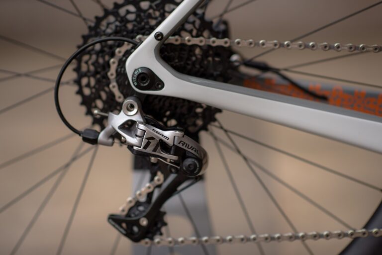 Zbliżenie na tylne koło i przerzutkę roweru, ze szczególnym uwzględnieniem mechanizmu zmiany biegów.