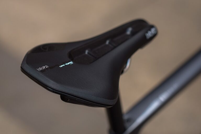 Zbliżenie na czarne siodełko rowerowe z nadrukowaną nazwą marki „pro” i modelem „griffon”, zamontowane na ramie roweru.