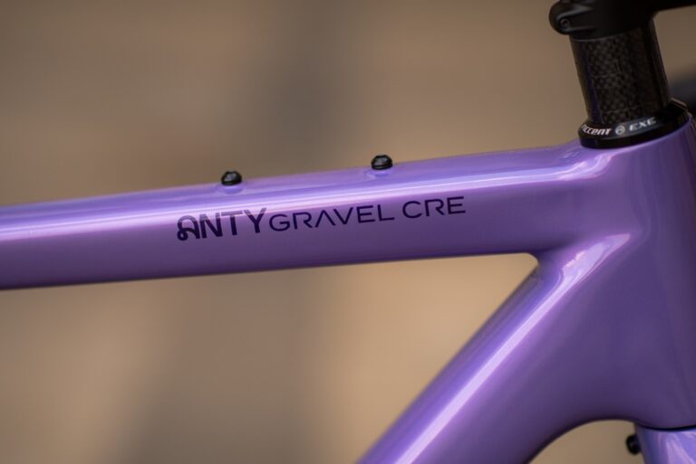 Zbliżenie na fioletową ramę roweru Anty Gravel CRE XS z nadrukowanym napisem „integral cre”, ukazującym szczegóły spawów i wykończenia.