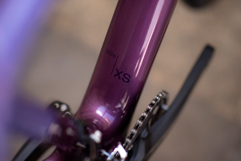 Zbliżenie na ramę roweru Anty Gravel CRE XS oznaczoną „xs” wskazującą na bardzo mały rozmiar, z częściowym widokiem na łańcuch rowerowy.