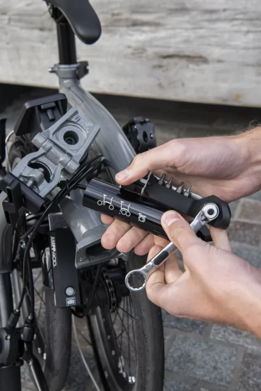 Osoba naprawia rower za pomocą zestawu narzędzi Multitool Brompton Toolkit.